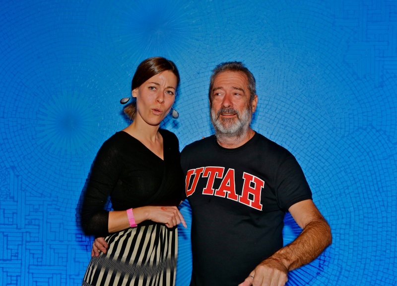 Curator Whitney Tassie and Artist Tony Feher pose in front of the window installation at the After-Hours Party.